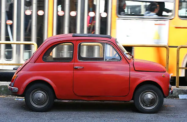 small red car parked in Rome Italy with a bus passing by-OTHER cute Italian cars and scooters: