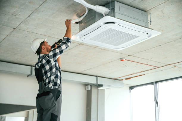 istock Fixing ventilation system. Repairman in uniform is in the unfinished building 1832640903