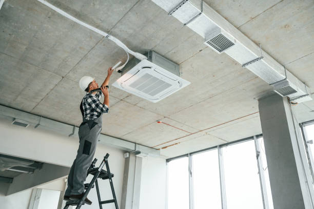 istock Fixing ventilation system. Repairman in uniform is in the unfinished building 1832640904