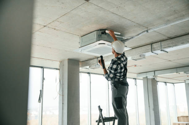 istock Fixing ventilation system. Repairman in uniform is in the unfinished building 1832640905