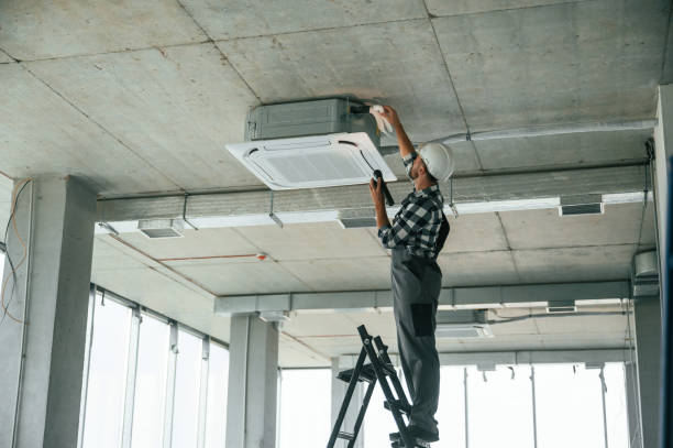 istock Setting the ventilation system. Repairman in uniform is in the unfinished building 1832640929