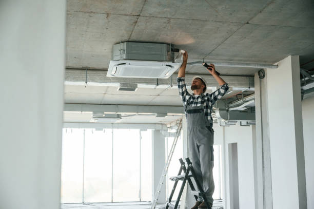 istock Setting the ventilation system. Repairman in uniform is in the unfinished building 1832640930