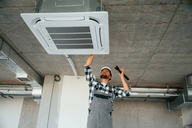 istock Using flashlight. Repairman in uniform is in the unfinished building 1832641236
