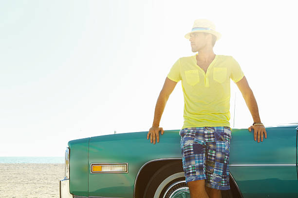 istock Young man wearing hat while leaning on his Cadillac car 183264685