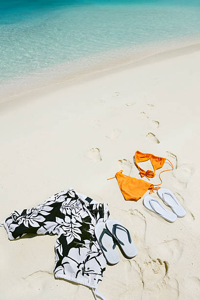 bikini and swimming trunks in sand on a Caribbean beach
