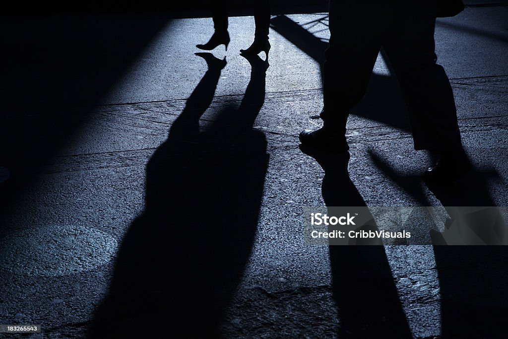 Мужской после женщина в голубой ночь теней - Стоковые фото Преследователь роялти-фри