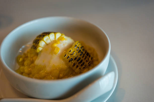 Grilled sweet corn and vanilla ice cream on white bowl, selective focus