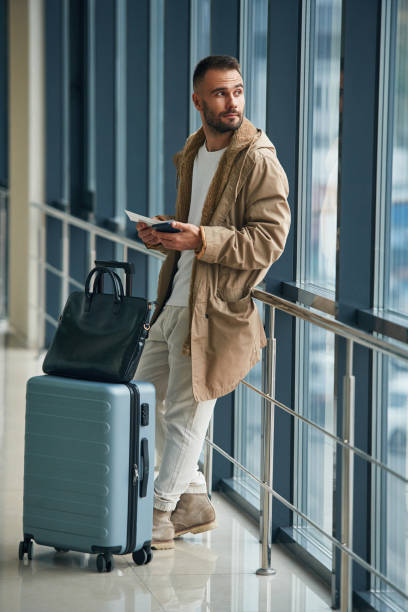 istock Waiting, standing inside. Young handsome man in the airport 1832661414