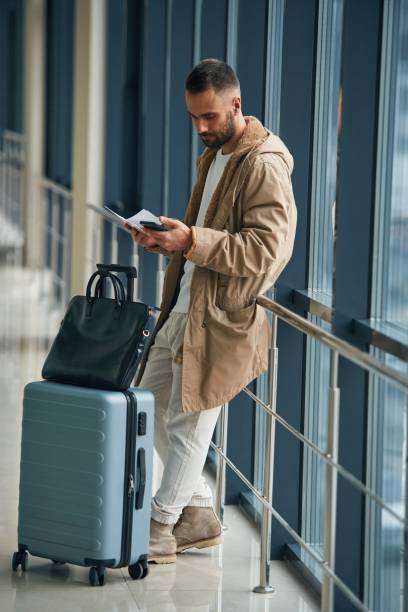 istock Smartphone in hands. Young handsome man in the airport 1832661935