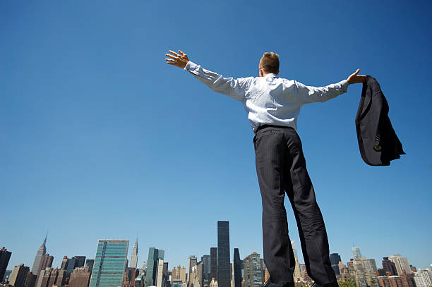 istock Businessman Standing with Arms Spread Above City Skyline 183266811