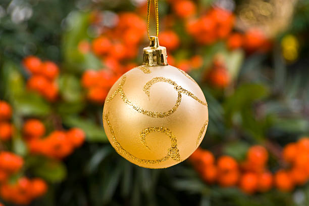Golden Ornate Bauble in Front of Christmas Decoration stock photo