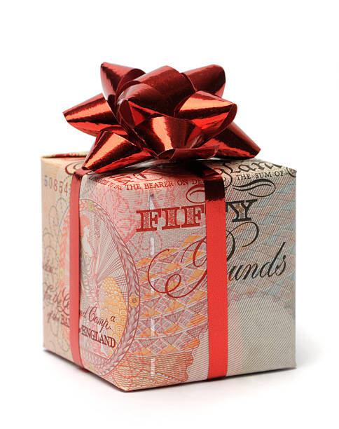 istock Gift box wrapped in an English pound with a red bow 183267394