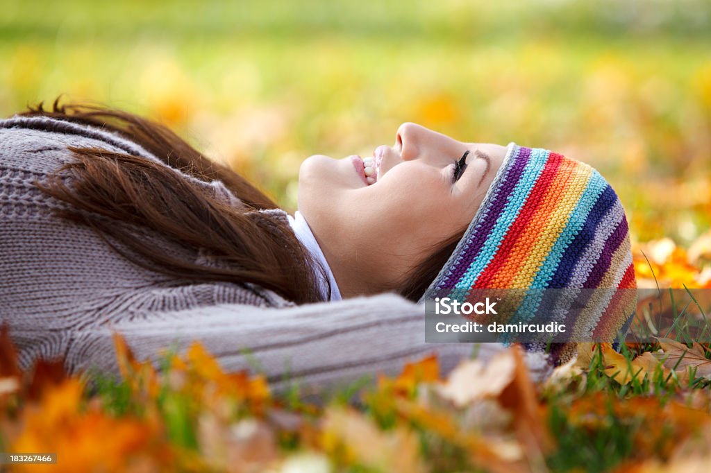 Mujer joven que descansan en seco hojas y disfrutar de la vida - Foto de stock de Acostado libre de derechos