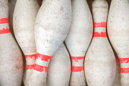 Vintage weathered white bowling pins with red stripe