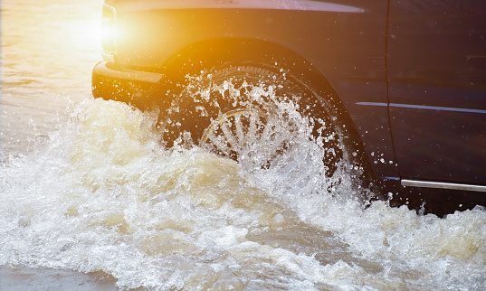 Closeup view of the rear wheel of a black pickup truck that was passing through a flood, car insurance and car fixing concept.