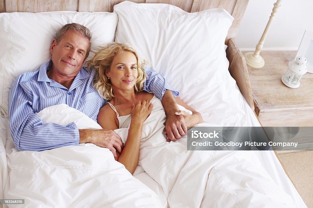 Mittleren Alter Mann mit Frau Lächeln beim liegen im Bett - Lizenzfrei Alter Erwachsener Stock-Foto