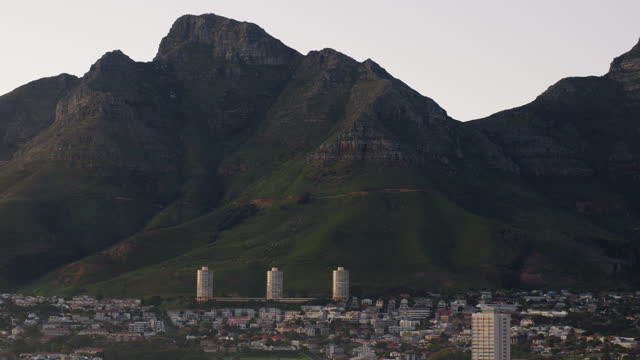 City, buildings and drone by mountains, outdoor and metro architecture, development and expansion in nature. Skyline, infrastructure and civil engineering for urban cityscape, landscape and Cape Town