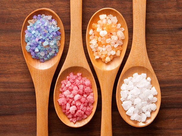 Bath salts and spoons Top view of spoons with variety of bath salts on them bath salt photos stock pictures, royalty-free photos & images