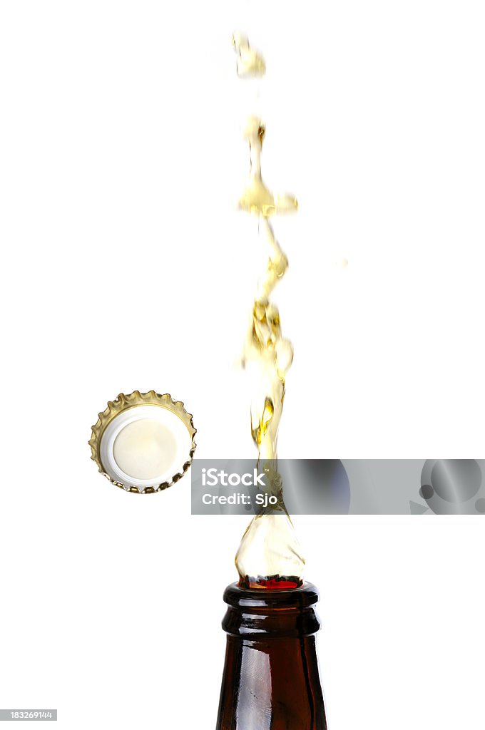 Beer splashing Beer splashing from the bottle with the cap flying in the air against a white background with a high key effect. Beer - Alcohol Stock Photo