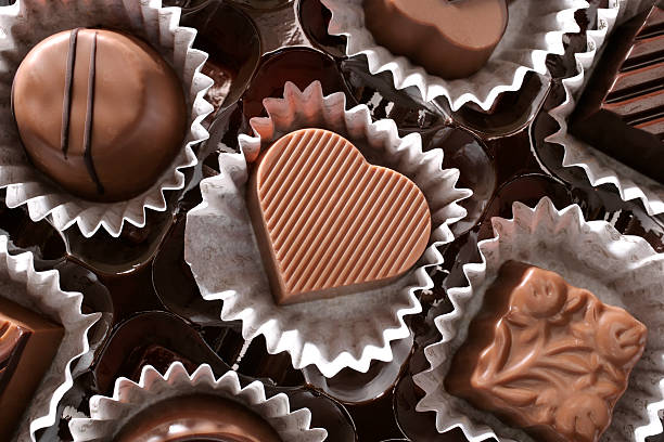 chocolates and love close up shot of chocolates in a row. heart shape valentines day chocolate candy food stock pictures, royalty-free photos & images