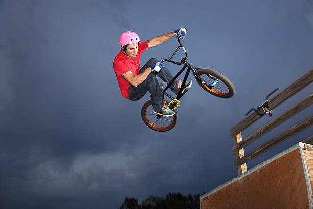 BMXer Airborne In Dark Cloudy Sky stock photo