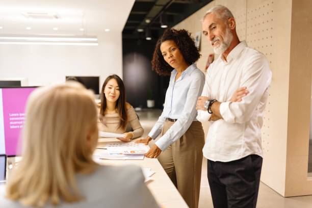 istock Man and woman talking about work with their colleagues 1832697929