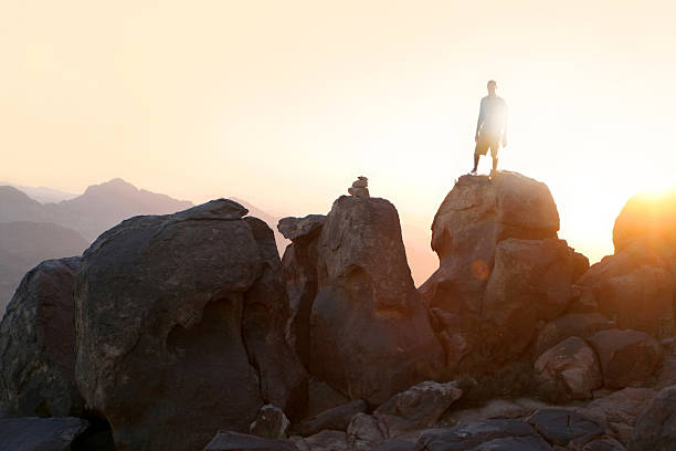 man standing on mountain summit stock photo