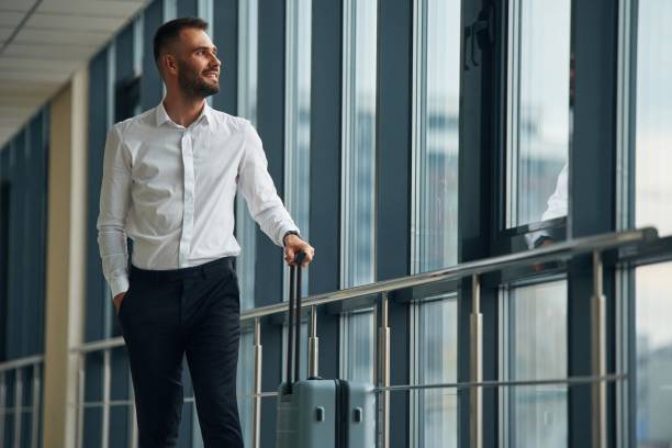 istock Standing, looking through the windows. Young handsome man in the airport 1832704268