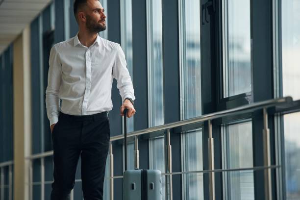 istock Standing, looking through the windows. Young handsome man in the airport 1832704269