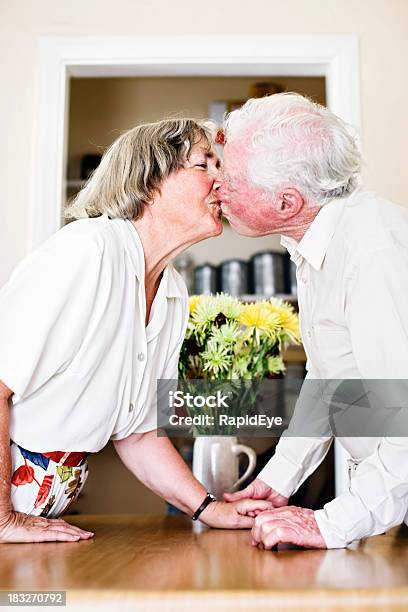 Sweet Elderly Couple Hold Hands And Kiss Stock Photo - Download Image Now - 70-79 Years, Active Seniors, Adult