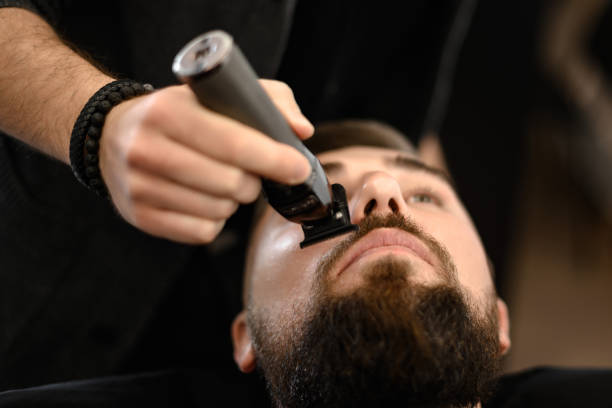 istock A barber trims a Caucasian clients mustache with a trimmer. 1832713311