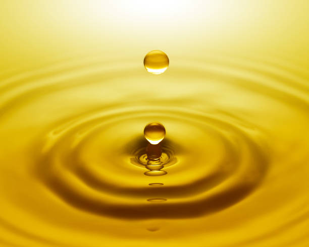 istock Close up of golden water drop and splash 1832714440