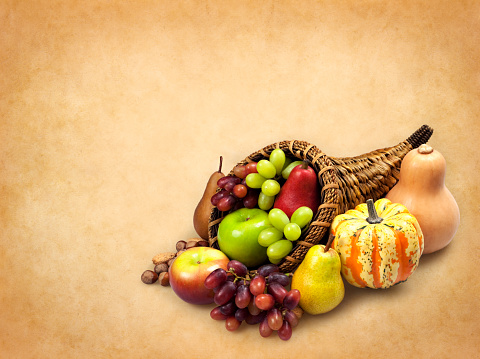 Autumn flat lay composition, with copy space on black background. Variety of edible and decorative gourds and pumpkins, cone, apple, flowers, kaki fruit and corn on the cob.