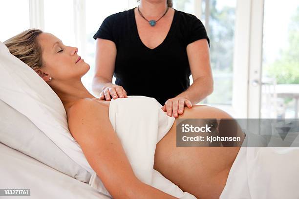 Pregnant Woman Receives Prenatal Massage And Reiki Energy Work Stock Photo - Download Image Now