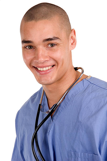 Male Nurse with Stethoscope 2 Male nurse standing with scrubs and stethoscope smiling male nurse male healthcare and medicine technician stock pictures, royalty-free photos & images