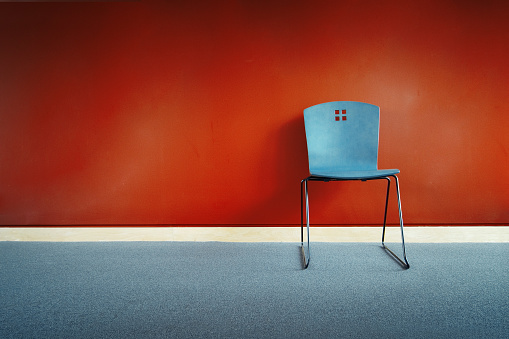 Blue chair against a red wall