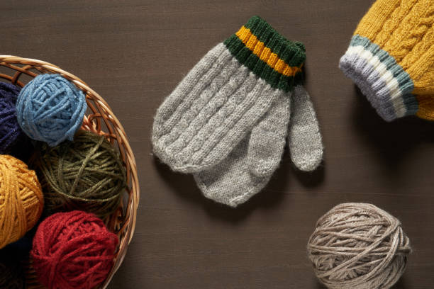 istock Winter woolen mittens with a pattern isolated on a wooden background. Winter accessory. 1832727032