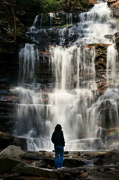 istock Woman standing in front of waterfall 183273074