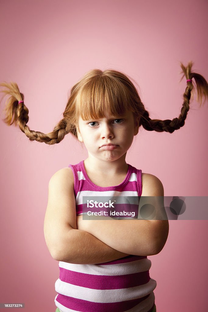 Irritabili a pelo rossa ragazza in piedi con le braccia incrociate in alto trecce, - Foto stock royalty-free di Bambino