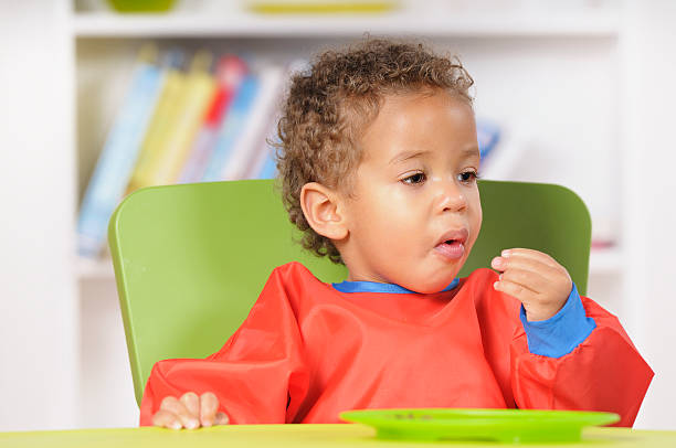 istock Baby Boy/ Toddler Eating In A Nursery Setting 183273598