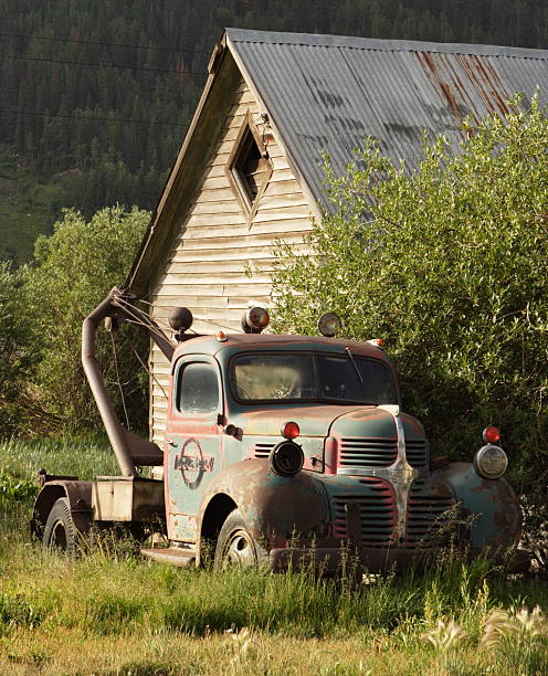 Truck Vintage Vehicle Rural Barn "Tow truck abandoned alongside rustic barn in remote high country farm landscape just after dawn. Silverton, Colorado, 2008." distressed rusty vintage pickup truck close up detail stock pictures, royalty-free photos & images
