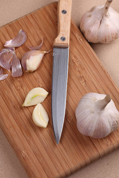 istock Garlic and knife on cutting board 183274015
