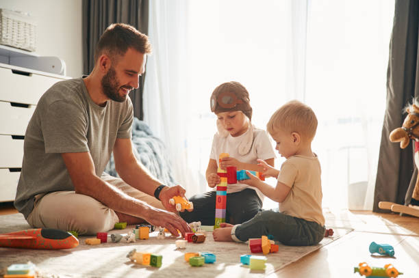 istock Construction toys. Father is playing with two little boys on the floor 1832743530