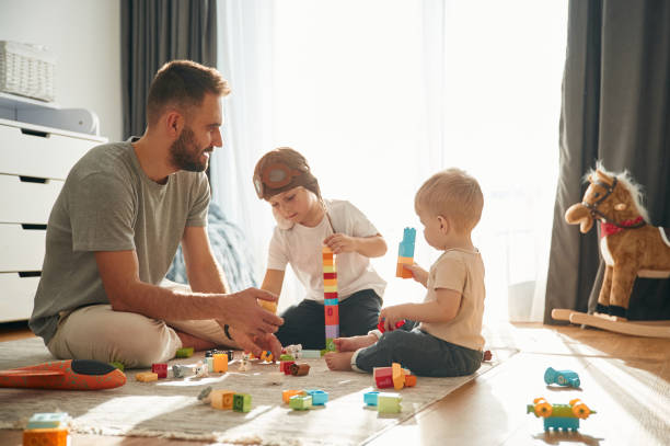 istock Construction toys. Father is playing with two little boys on the floor 1832743534