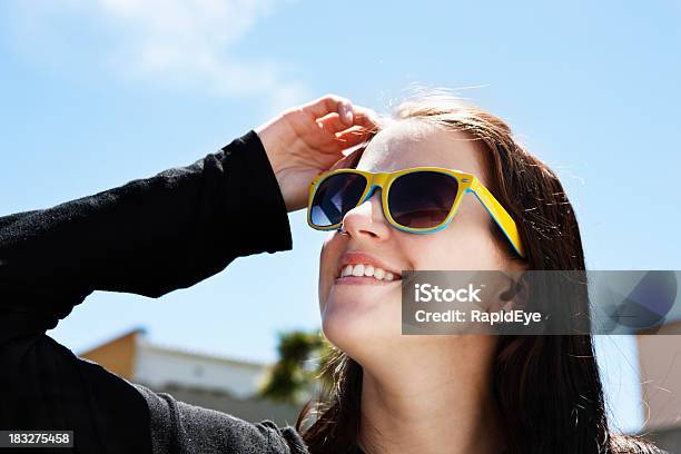 Smiling Brunette In Sunglasses Shields Eyes From Bright Sunlight Stock Photo - Download Image Now