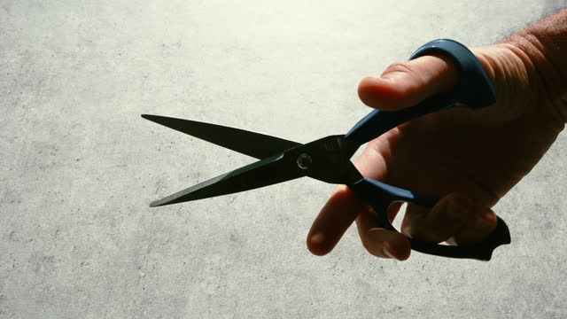 Hand holding pair of scissors