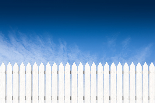 Picket fence with blue sky in the background.