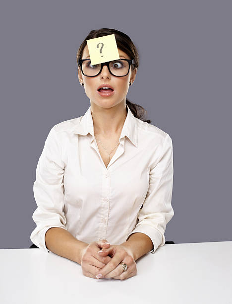 Business woman with question mark note stuck on forehead Portrait of a confused business woman with question mark on adhesive note stuck on forehead question mark depression sitting asking stock pictures, royalty-free photos & images