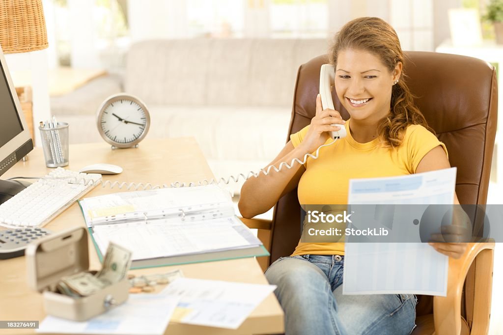 Jovem mulher falando no telefone sobre finanças - Foto de stock de 20 Anos royalty-free