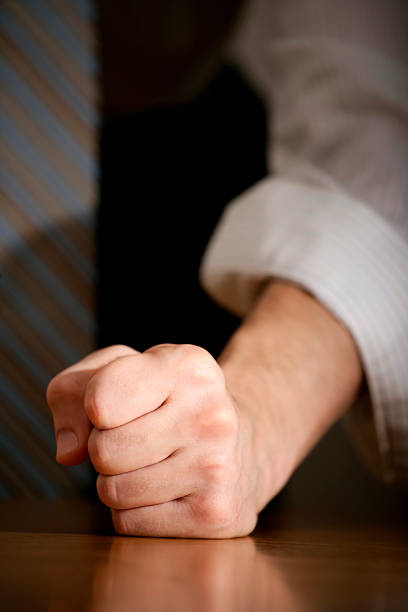 Businessman hitting table with clenched fist.
